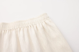 Dettaglio della vita alta elastica su gonna in tessuto di lino color bianco avorio