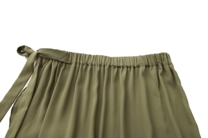 Detail of army green wrap skirt featuring elastic waistband and adjustable ribbon tie