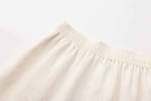 Dettaglio dell'elastico in vita e della trama in cotone lino sulla gonna lunga beige