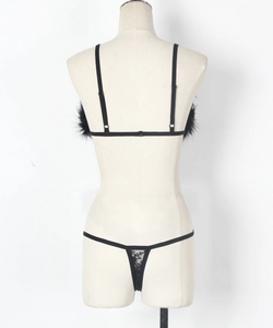 Close-up of black lace lingerie set with feather trim and adjustable shoulder straps