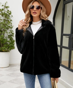 Détail de veste noire en fausse fourrure à capuche avec fermeture éclair et texture peluche
