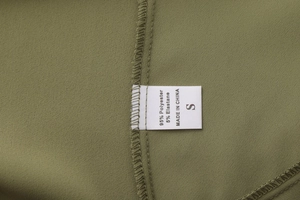 Detail of olive green wrap skirt fabric tag showing 95% polyester and 5% elastane blend