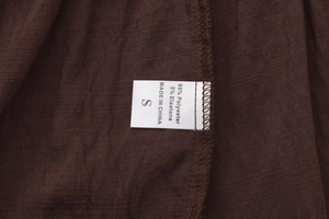 Détail de l'étiquette indiquant 95% polyester et taille S sur une jupe longue marron