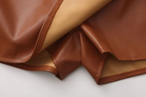Detailed close-up showing brown PU leather texture and precise double-stitched hem finish