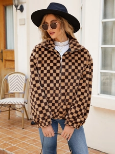 Close-up of brown checkerboard plush jacket showing soft faux fur texture and zipper detail