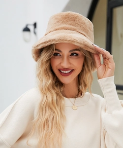 Modella all'aperto con un cappello alla pescatora in morbida ecopelliccia color cammello