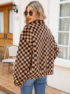 Detail of faux fur camel checkered coat with plush collar and elastic cuffs on a street