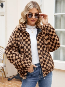 Detail of checkered plush jacket with metal zipper and high collar in brown tones