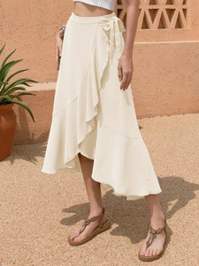 Cream wrap midi skirt with ruffle hem and side tie waist in a sunny outdoor setting