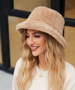 Dettaglio di un caldo cappello a secchiello in peluche color cammello con finta pelliccia