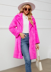Détail de la texture en fausse fourrure douce d'un long manteau d'hiver rose vif pour femme