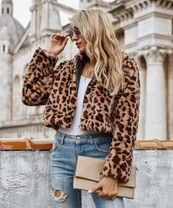 Veste courte en fausse fourrure léopard portée avec un jean bleu délavé en extérieur