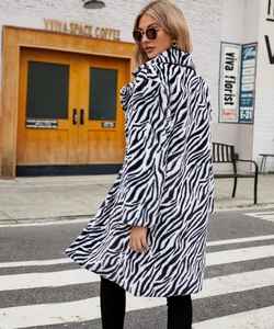 Outdoor street view of a zebra print faux fur coat with oversized lapels and plush texture