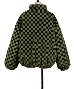 Detail view of green and black checkerboard faux fur jacket with elastic cuffs