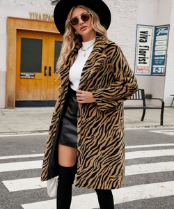Outdoor street view of tiger print faux fur coat with oversized lapels and long sleeves