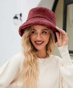 Modella indossa un cappello a secchiello bordeaux in ecopelliccia per calore e stile