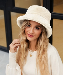 Dettaglio della texture di un cappello a secchiello in morbida ecopelliccia crema