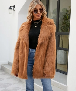 Détail d'un manteau en fausse fourrure caramel avec texture pelucheuse et larges revers
