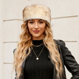Outdoor shot of a thick faux fur winter hat in beige and brown on a model