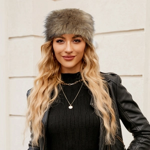 Faux fur trapper hat in taupe grey mix worn by model for winter warmth and fashion