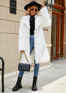 Detail showing the thick texture and fluffy faux fox fur of the white long-sleeve coat