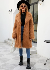 Brown faux fur coat styled with black wide-brim hat and blue jeans for winter fashion