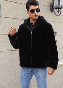 Detail of soft black faux fur texture on men's zip-up hooded jacket in street setting