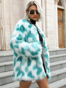 Close-up of fluffy green and white faux fox fur coat with stylish patchwork design