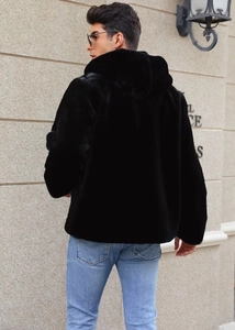 Detail of the hooded black faux fur jacket showing plush texture and urban street style