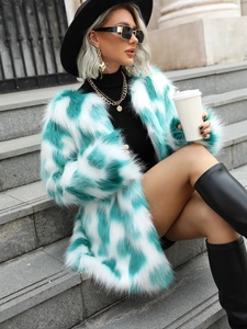 Detail of faux fur coat in white and mint green checkerboard pattern on outdoor model