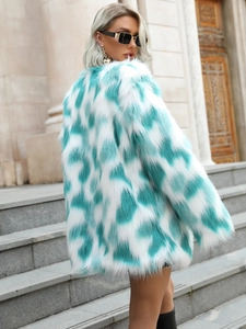 Detailed texture of white and mint green faux fox fur coat with oversized contrast spots