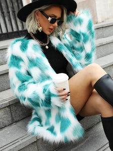 Detailed close-up of green and white faux fox fur coat texture with long plush fibers