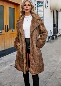 Outdoor street view of a women's brown faux fox fur coat with a stylish lapel collar