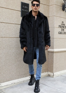 Front view of men's long black faux fur coat styled with jeans and leather boots