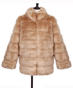Detailed view of camel faux fur coat featuring horizontal tiered stitching and plush collar