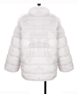 Close-up of white faux fur coat featuring horizontal striped stitching and plush texture