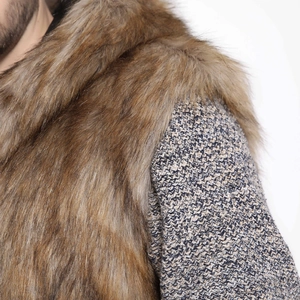 Close-up of fluffy faux fox fur collar and textured tweed fabric on men's winter vest