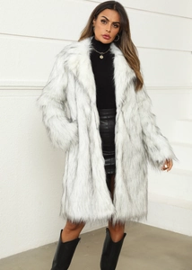 Full-body shot of long white faux fox fur coat with black tips and stylish winter boots