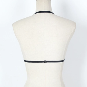 Detail of minimalist black lace bralette straps with metallic back hook on mannequin