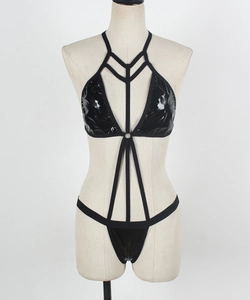Détail d'une lingerie en cuir verni brillant avec harnais élastique et anneau métallique