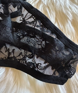 Close-up of black floral lace lingerie detailing with delicate patterns and elastic trim