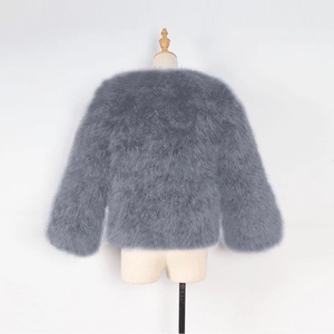 Detailed macro view of gray long-sleeve faux fur jacket with fluffy texture for kids