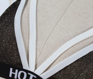 Detailed macro view of black glitter fabric sports bra with white HOT elastic band