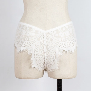 Gros plan sur une culotte en dentelle blanche transparente avec bordure en cils et coupe en V