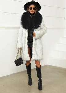 Vue complète d'un long manteau en fausse fourrure blanche avec col noir pour l'hiver