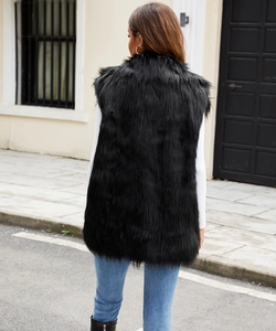 Back view of a long black faux fur vest paired with white shirt and blue jeans