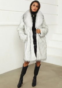 Gros plan détaillé d'un manteau en fausse fourrure blanche à pointes noires avec grand revers