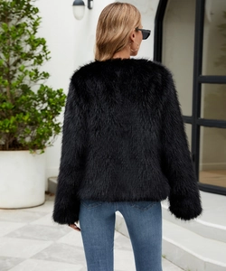 Back view of a fluffy black faux fur coat for women with long hair texture outdoors
