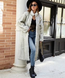 Vue complète d'un long manteau en fausse fourrure blanc cassé avec texture en peluche douce