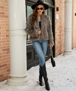 Winter street style view of woman in cropped grey-brown faux fur coat and blue jeans